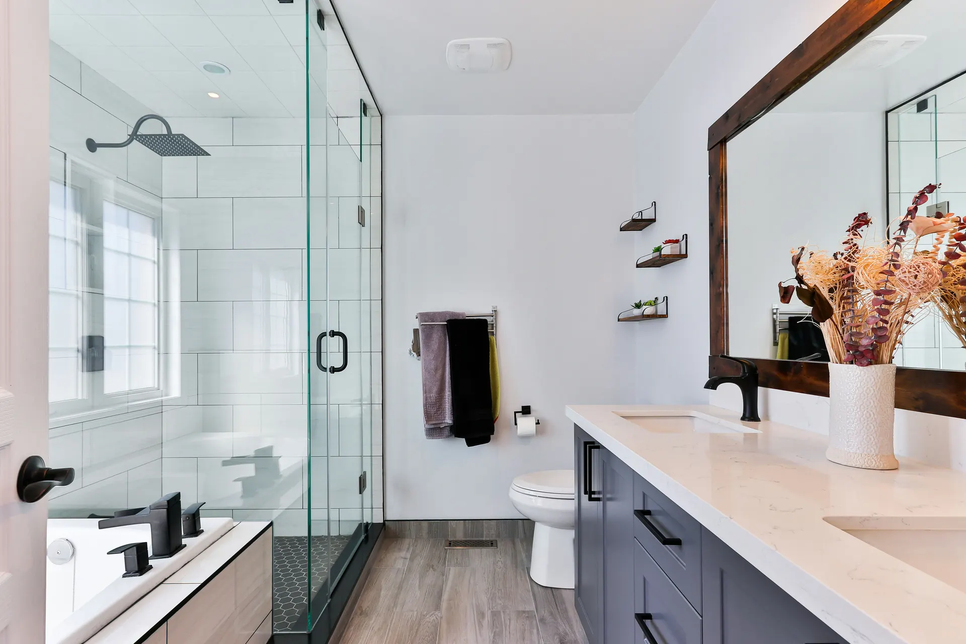 Salle de bain rénovée avec douche vitrée et meuble vasque blanc