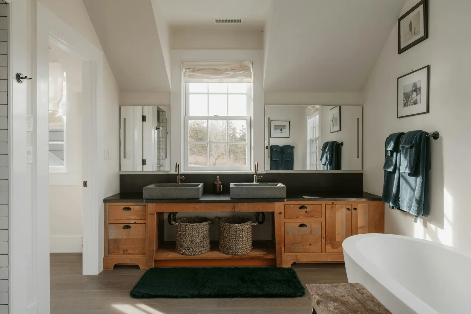Grande salle de bain avec meuble double vasque en bois et baignoire îlot